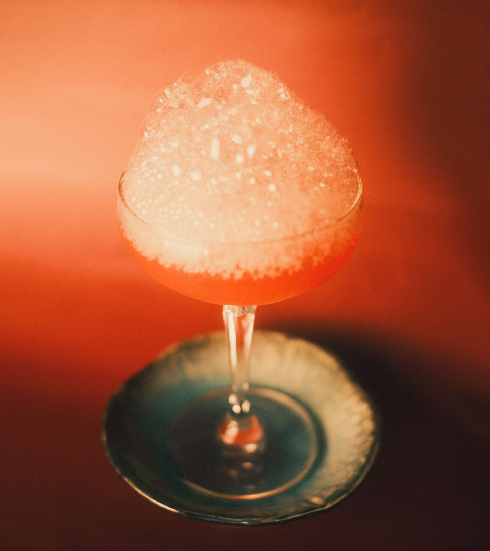 RRR 시그니처 칵테일 — 섬세한 거품과 코랄 빛 칵테일